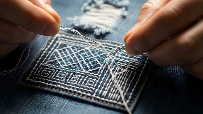 Handen naaien witte steken in een donkerblauw stoffen lapje