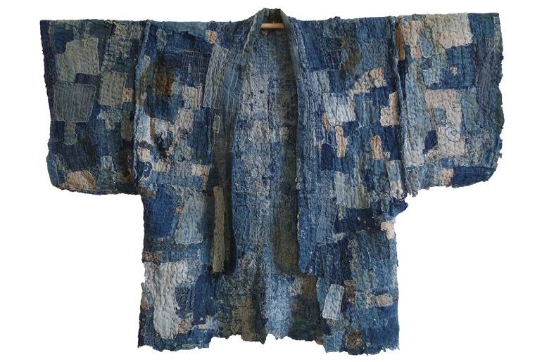 Blauw Japans textiel met zichtbare lapjes en reparatiesteken